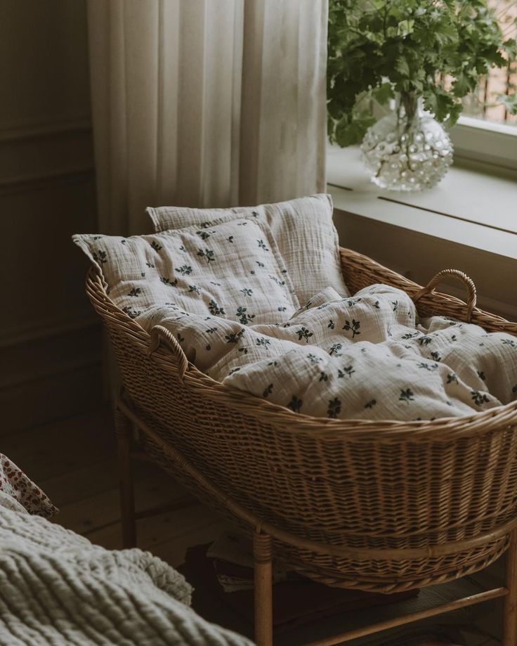 “Baby sleeping in a wicker bassinet with neutral baby bedding in a cosy nursery”