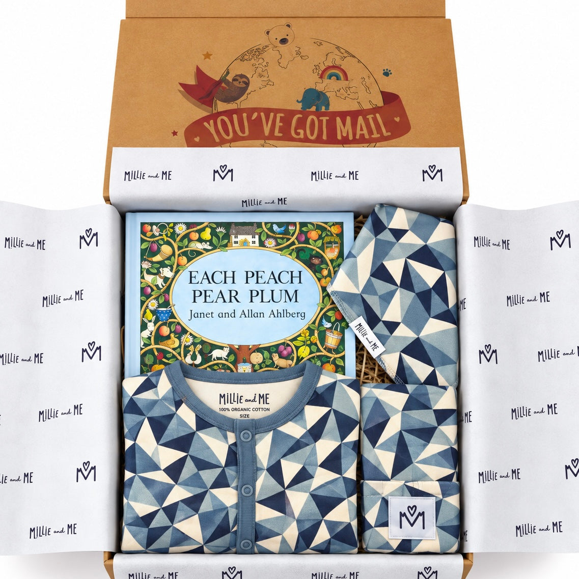 A curated gift box from Millie and Me, featuring a children's book titled 'Each Peach, Pear, Plum' nestled between two matching geometric-patterned baby clothes and surrounded by branded tissue paper. The open kraft cardboard lid features a colorful illustration and the text 'YOU'VE GOT MAIL'.