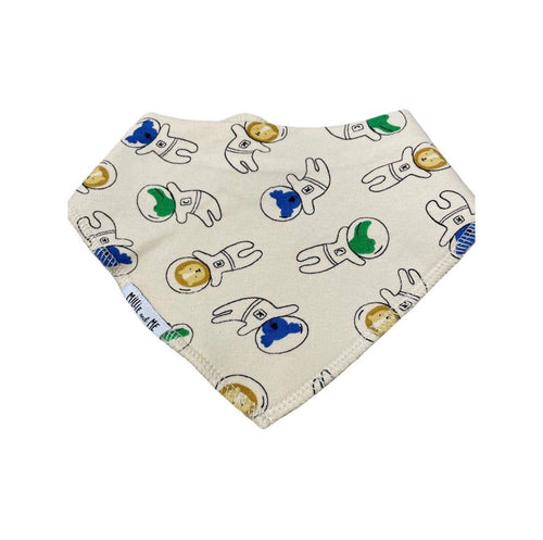 A triangular baby bib with an off-white background, featuring a repeating pattern of cartoon astronauts in white suits with blue and green helmets. The brand name 'Millie and Me' is visible on a small fabric tag near the bottom left edge.