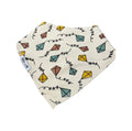 An off-white cotton bandana bib featuring a colorful pattern of paper kites and black squiggle lines, with a white fabric label on the side.