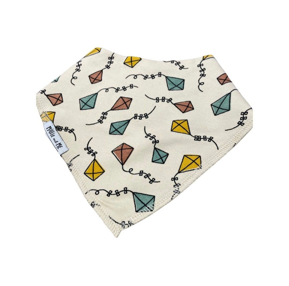 An off-white cotton bandana bib featuring a colorful pattern of paper kites and black squiggle lines, with a white fabric label on the side.