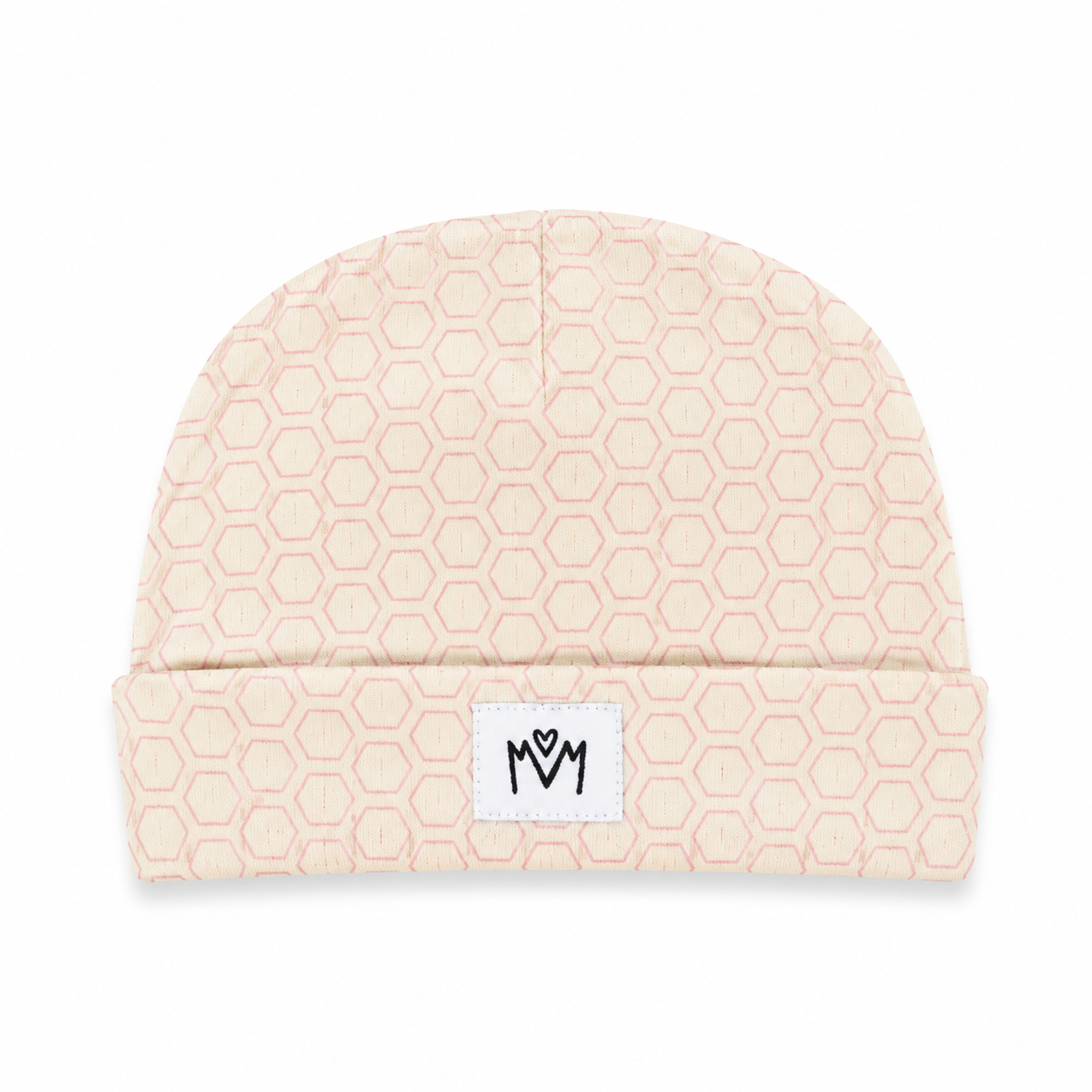 A light beige knit beanie with a repeating hexagon pattern in a soft pink, featuring a white rectangular patch on the folded cuff with a black stylized logo.