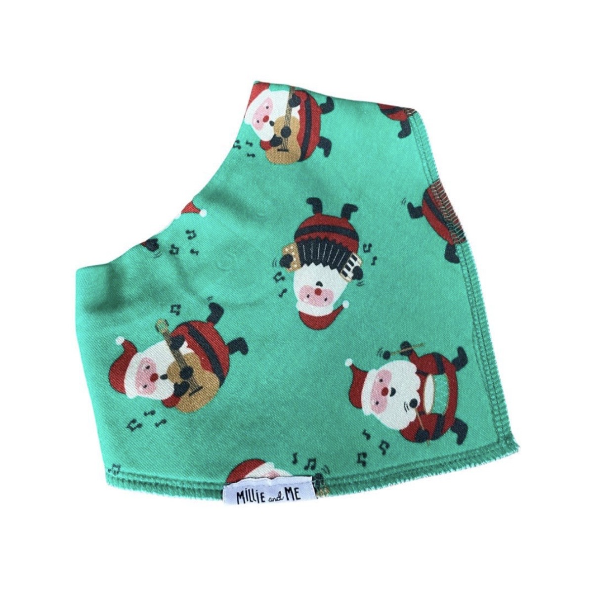 A mint green pet bandana featuring a festive pattern of cartoon Santa Claus and dog characters, with a white fabric tag reading 'Millie and Me' at the bottom.