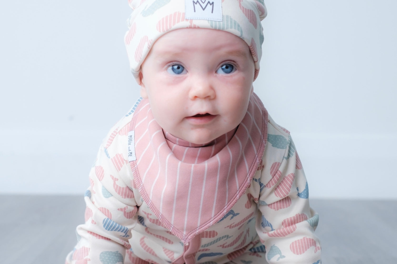 Pink bandana bib with vertical stripe design.