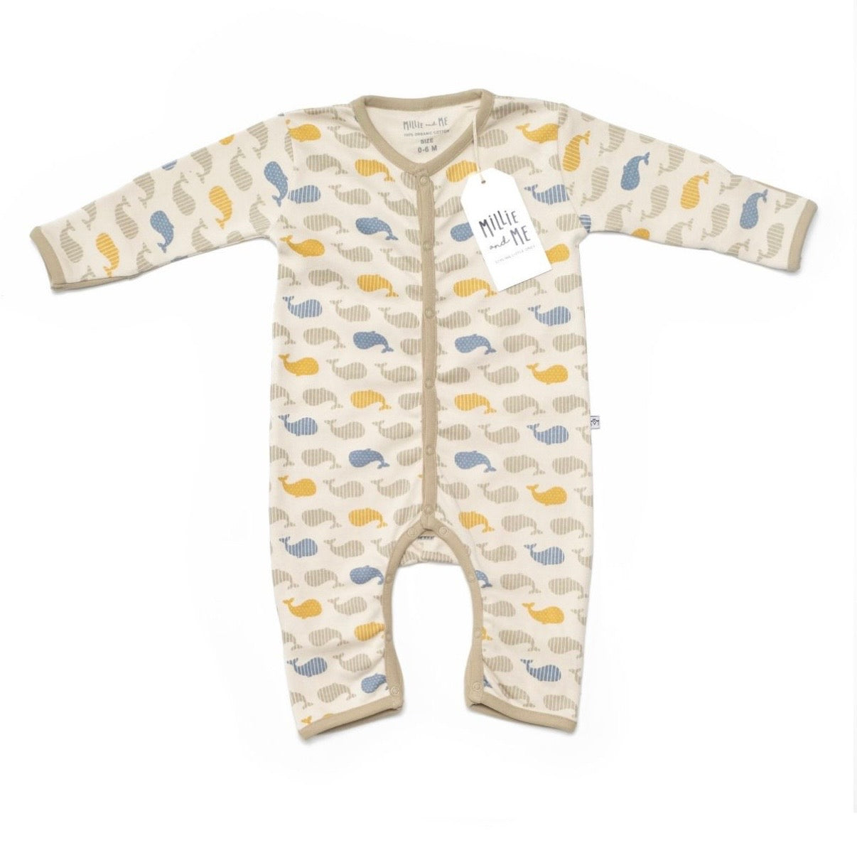 A baby long-sleeve footless sleeper in cream with a repeating pattern of whales in yellow and blue, featuring a front buttons and a hangtag.
