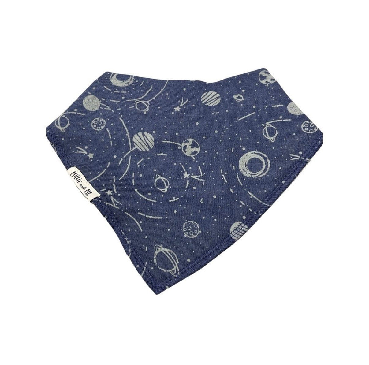 A navy blue bandana bib with a white space-themed print of planets, stars, and orbits, featuring a small white brand tag that reads 'Millie and Me'.