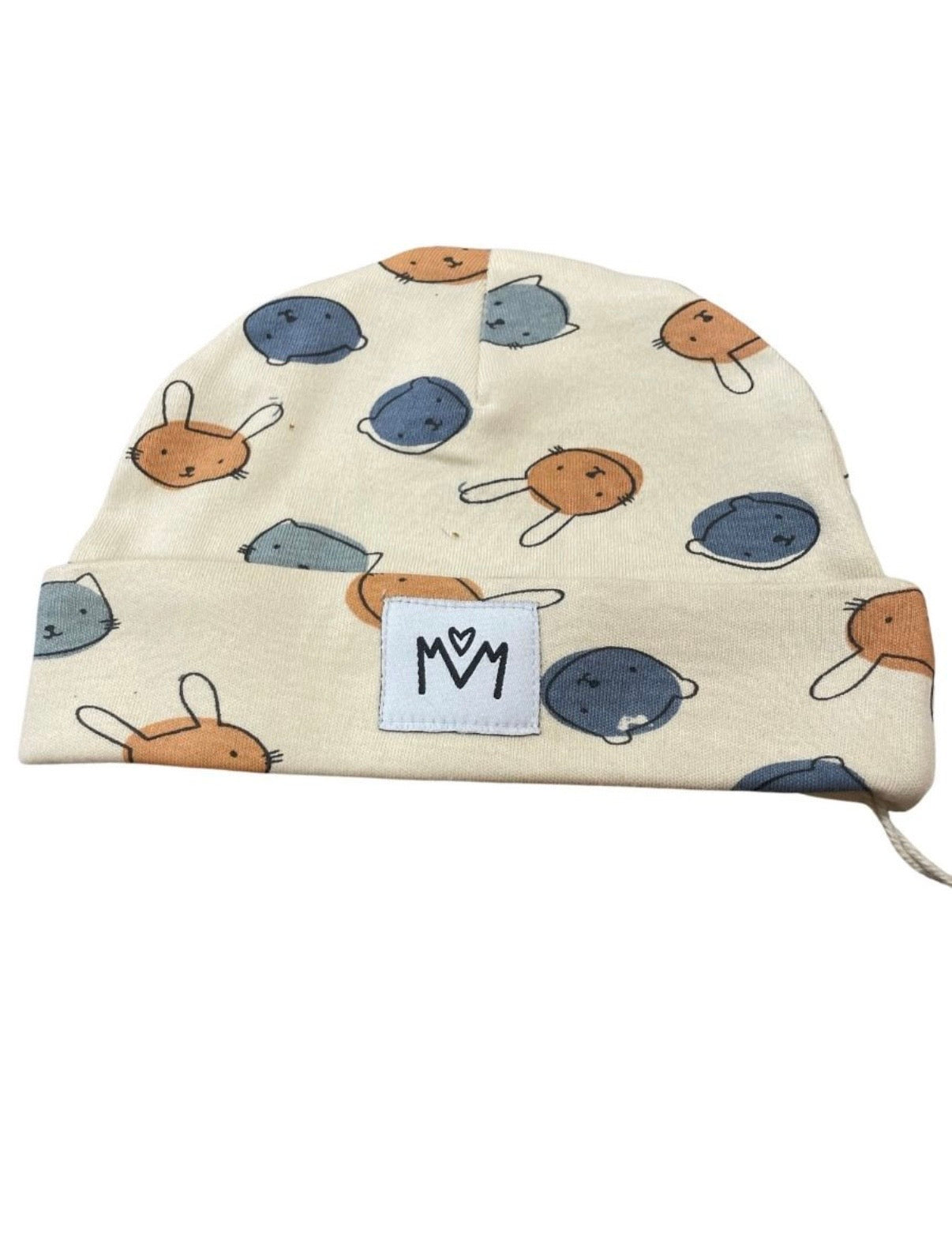 A cream-colored baby beanie hat featuring a playful pattern of cartoon bunnies in orange, blue, and gray, with a white fabric patch on the front displaying the black logo.