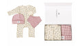 A baby clothing gift set shown both laid out and inside its white box. The set includes a cream-colored long-sleeve footless romper with a delicate floral print, a matching pink and white gingham bib, and a folded matching gingham blanket or swaddle.