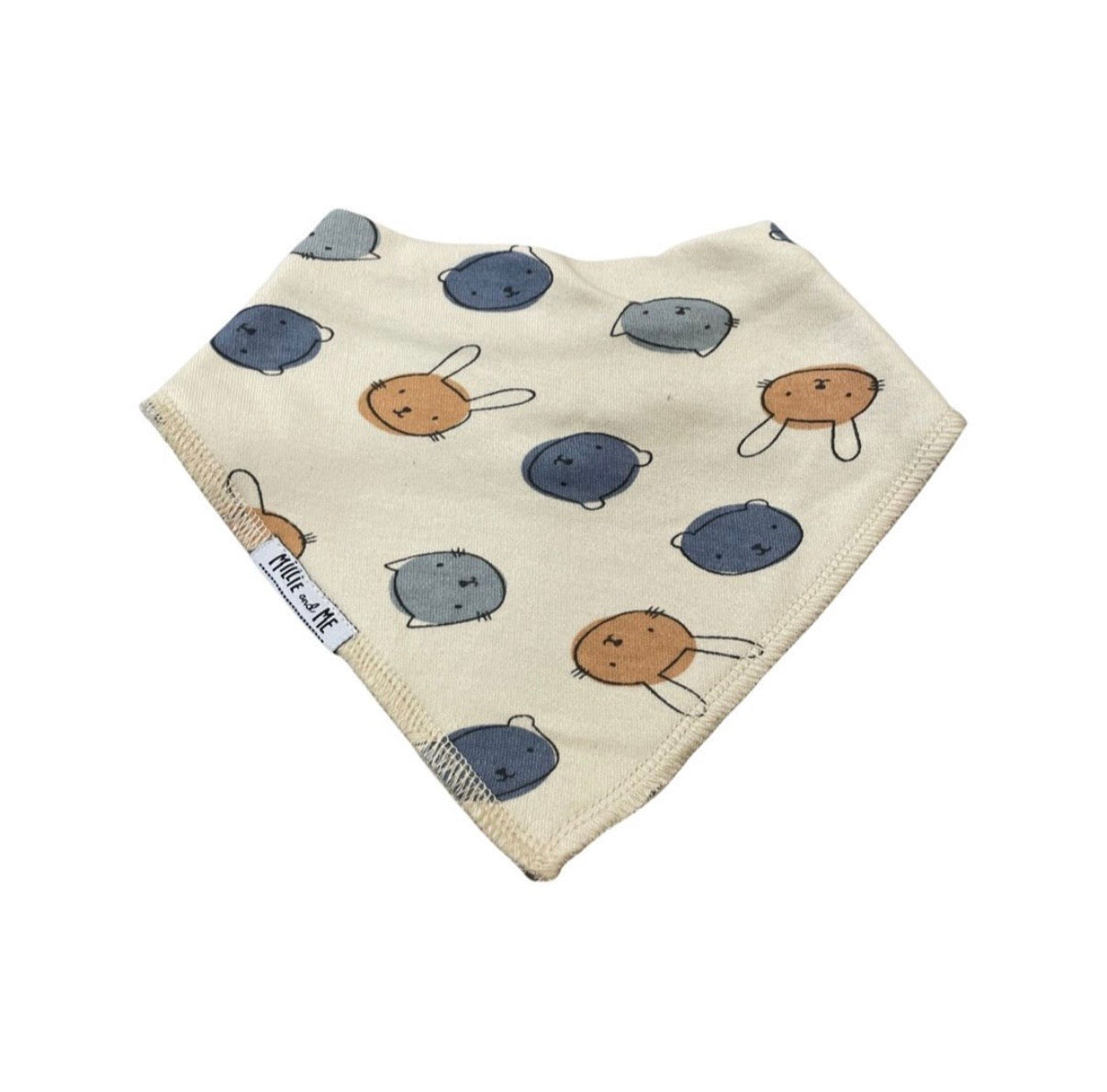 A triangular baby bib made of cream-colored fabric with a pattern of blue-gray and tan cartoon bunnies, featuring a white tag on the side.