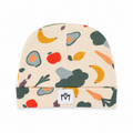 A cream-colored baby beanie hat featuring a colorful pattern of illustrated fruits, vegetables, and avocadoes, with a white fabric patch on the cuff displaying the 'MM' logo.