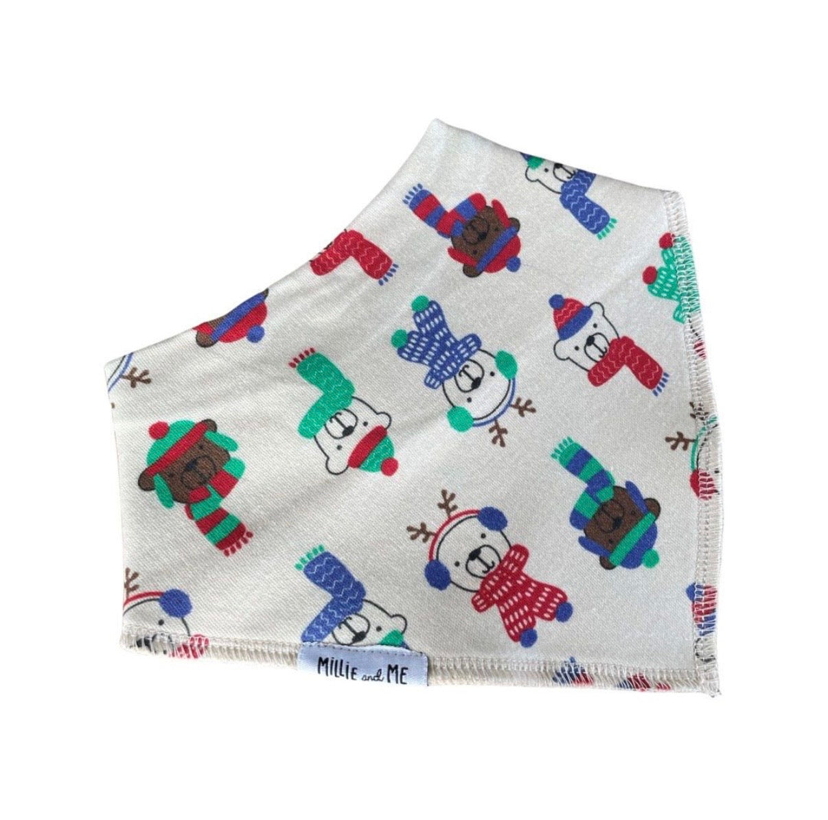A folded white fabric face mask featuring a colourful pattern of cartoon polar bears wearing winter scarves and hats, with a small white tag reading 'Millie and Me' at the bottom edge.