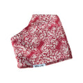 A folded red fabric item with a white repeating floral and animal pattern, shown on a plain white background. A small white label near the bottom reads 'Millie and Me'.