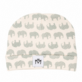 A knit baby beanie hat featuring a repeating pattern of gray elephants on a warm cream background, with a small white brand patch on the front.