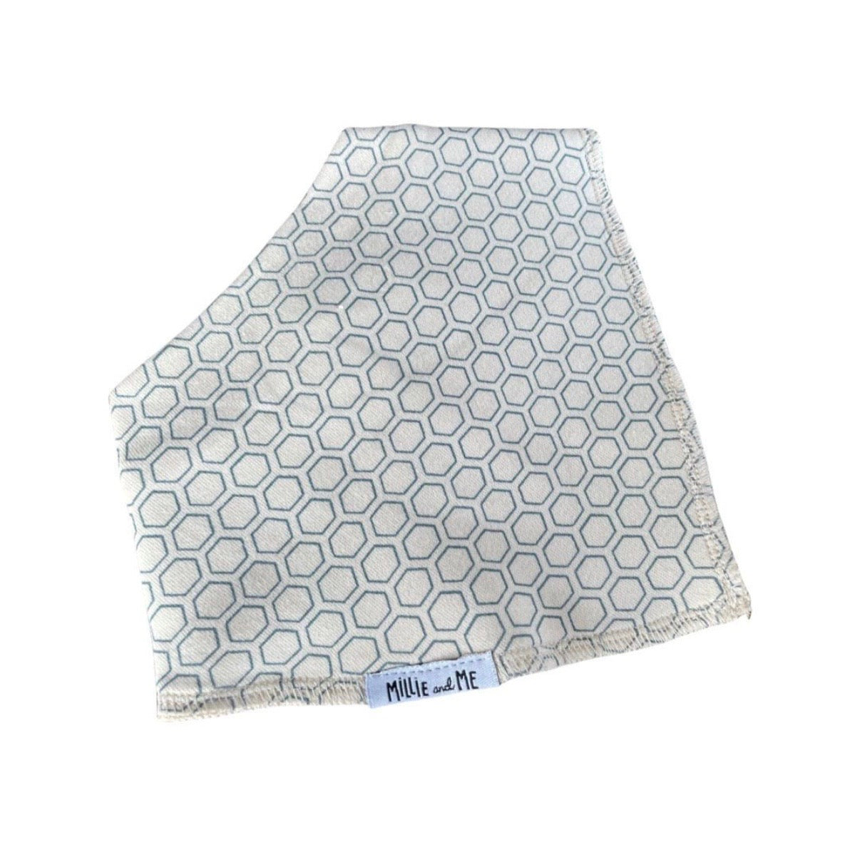 A square baby blanket or swaddle with a light blue and white geometric hexagon pattern, featuring fringed edges and a small white brand label reading 'Millie and Me' at the bottom.