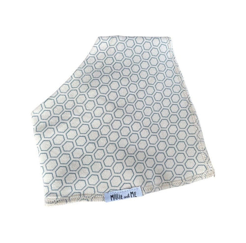 A square baby blanket or swaddle with a light blue and white geometric hexagon pattern, featuring fringed edges and a small white brand label reading 'Millie and Me' at the bottom.