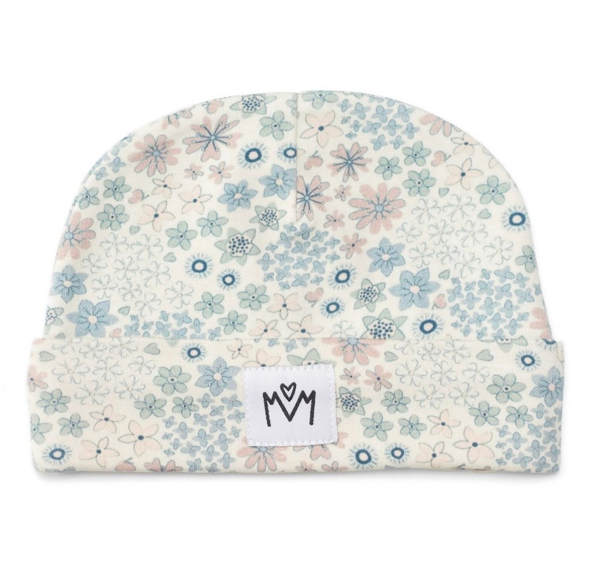 A folded baby beanie hat featuring a delicate floral pattern in shades of blue, pink, and green on a warm cream background. A small white square patch with a black hand-drawn logo is sewn onto the front cuff.