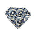 A triangular bandana bib with a geometric triangle pattern in navy blue, slate blue, and cream, featuring a visible 'Millie and Me' brand label on the side.