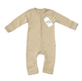 A long-sleeve baby footless one-piece sleeper in a light beige colour, featuring a white hangtag with the brand name 'Millie and Me' on a clean white background.