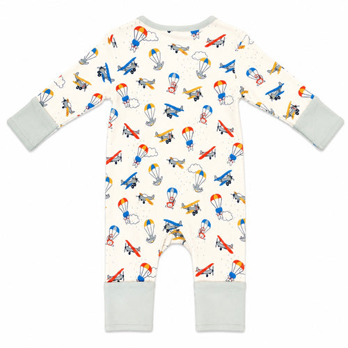 A baby's long-sleeve footless romper in cream with a colorful airplane and parachute pattern, featuring light gray cuffs and leg cuffs, shown flat on a white background.