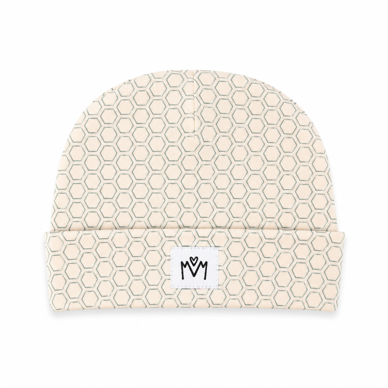 A beige beanie with a repeating light gray hexagonal pattern and a white rectangular patch on the folded cuff featuring a black stylized 'MM' logo.