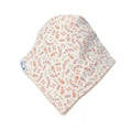 A soft baby bonnet or hat made of cream-colored fabric with a delicate all-over botanical pattern in muted terracotta and sage green, featuring a small white fabric brand tag on the side.