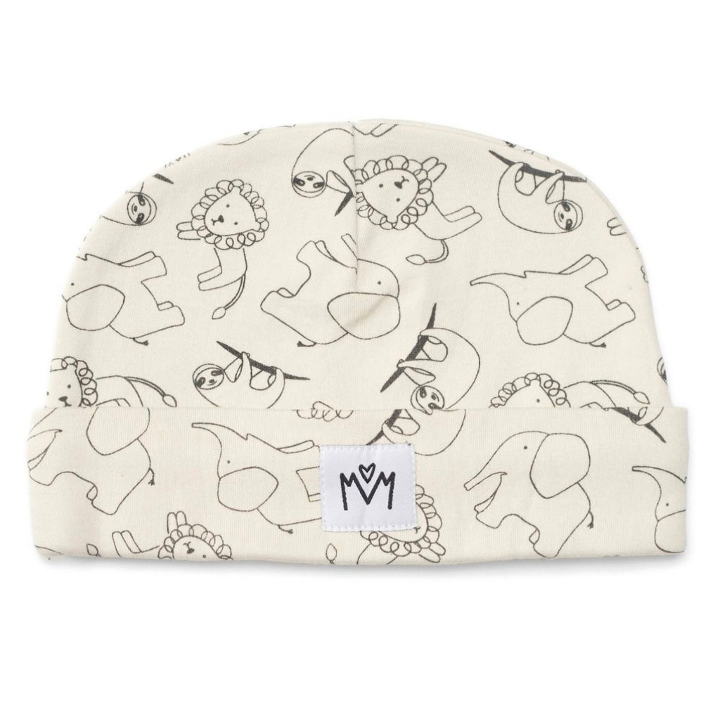 An off-white baby beanie with a black line art pattern of whimsical animals, featuring a small white brand patch with the letters 'MM' on the cuff.
