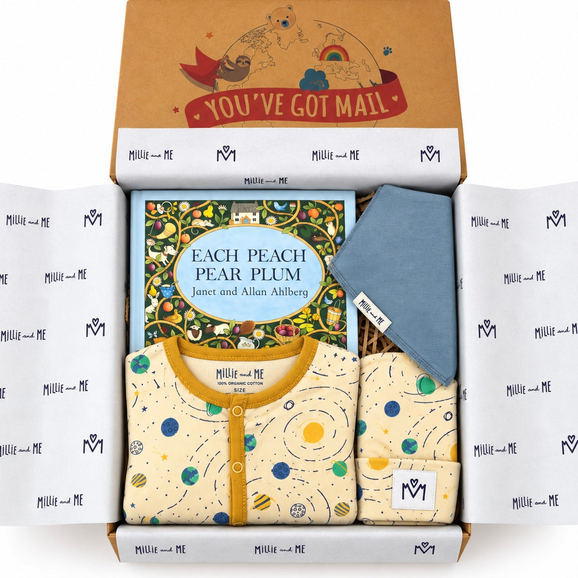 A curated baby gift box from Millie and Me, featuring a children's book, a yellow and cream patterned babygrow, a dusty blue bandana bib, and a brown cardboard box with a 'YOU'VE GOT MAIL' illustration, all neatly arranged on a white background.