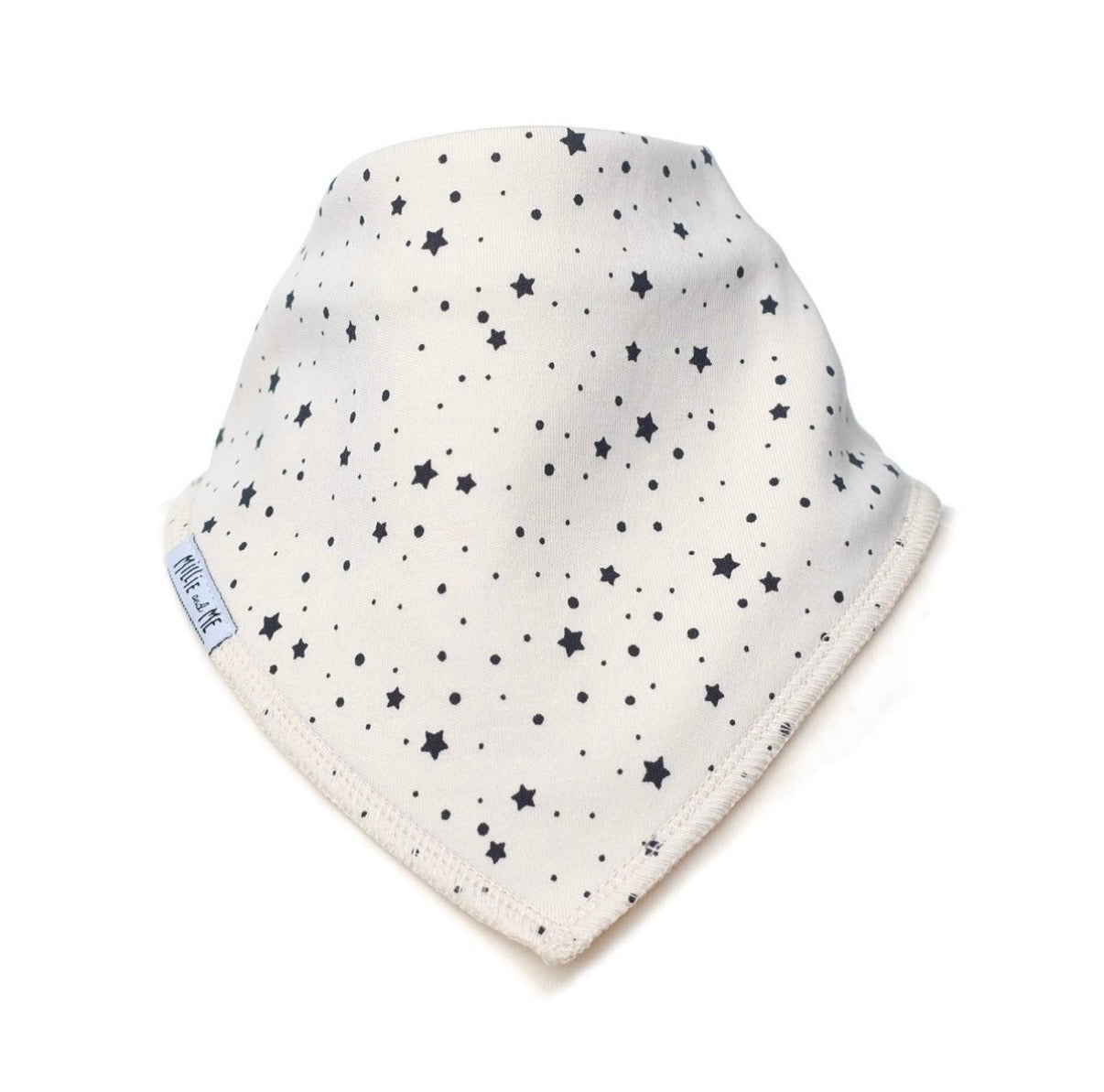 An off-white baby bandana bib with a black star and dot pattern, featuring a small side tag that reads 'Millie and Me'.