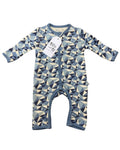 A baby long-sleeve footless one-piece sleeper with a geometric triangle pattern in shades of blue, navy, and cream, featuring a white hangtag with the brand name 'Millie and Me'.