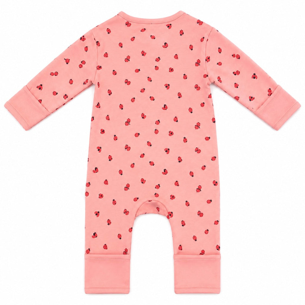 A pink long-sleeve baby romper with a small red strawberry print, shown flat against a white background.