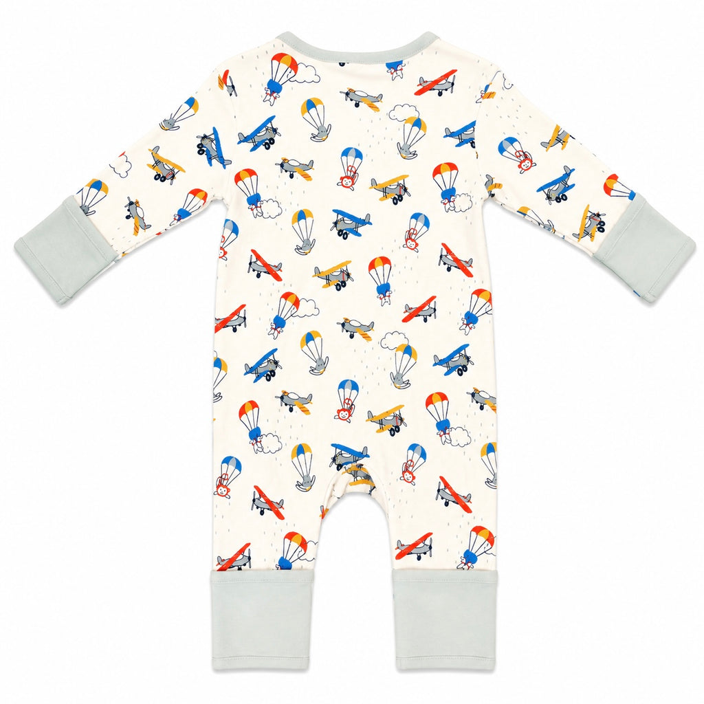 A baby's long-sleeve footless romper in cream with a colorful airplane and parachute pattern, featuring light gray cuffs and leg cuffs, shown flat on a white background.