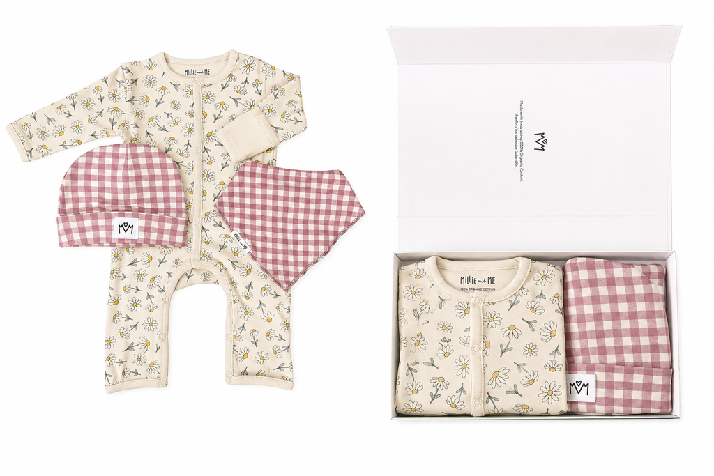 Baby clothing gift set shown flat on a white background, with a floral long-sleeve romper, matching pink gingham pants, and a matching pink gingham beanie, alongside an open gift box containing the same items.