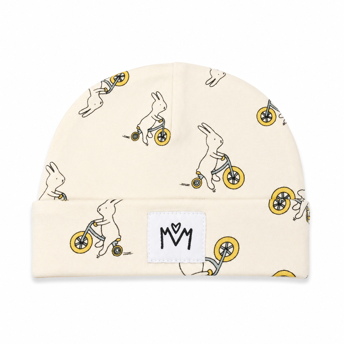 A cream-colored knit beanie hat featuring an all-over print of white rabbits riding yellow bicycles. A white rectangular patch on the folded cuff displays a black stylized 'MM' logo.