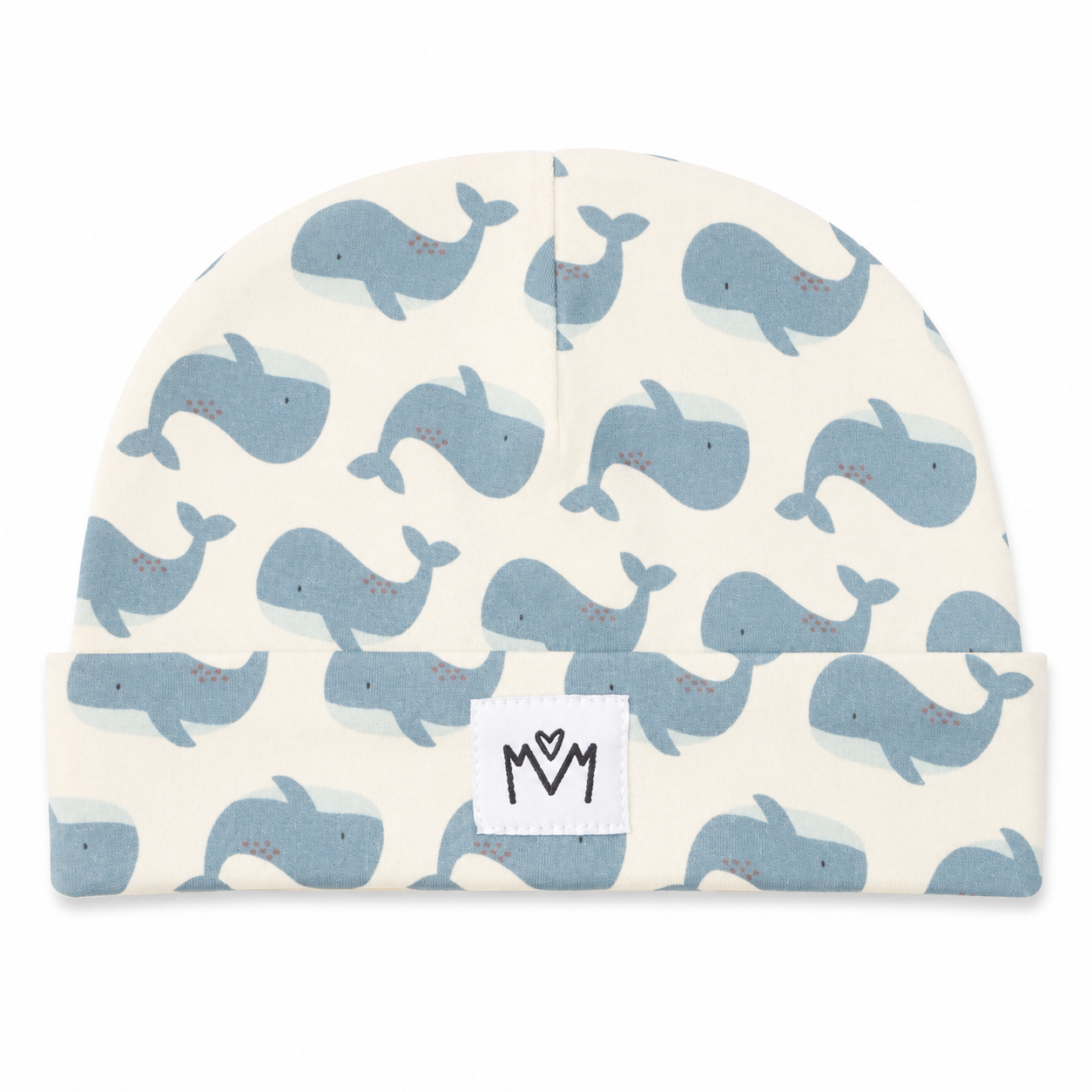 A baby beanie hat featuring a repeating pattern of light blue whales on an off-white background, with a white fabric patch on the cuff displaying a black hand-drawn 'MOM' logo.
