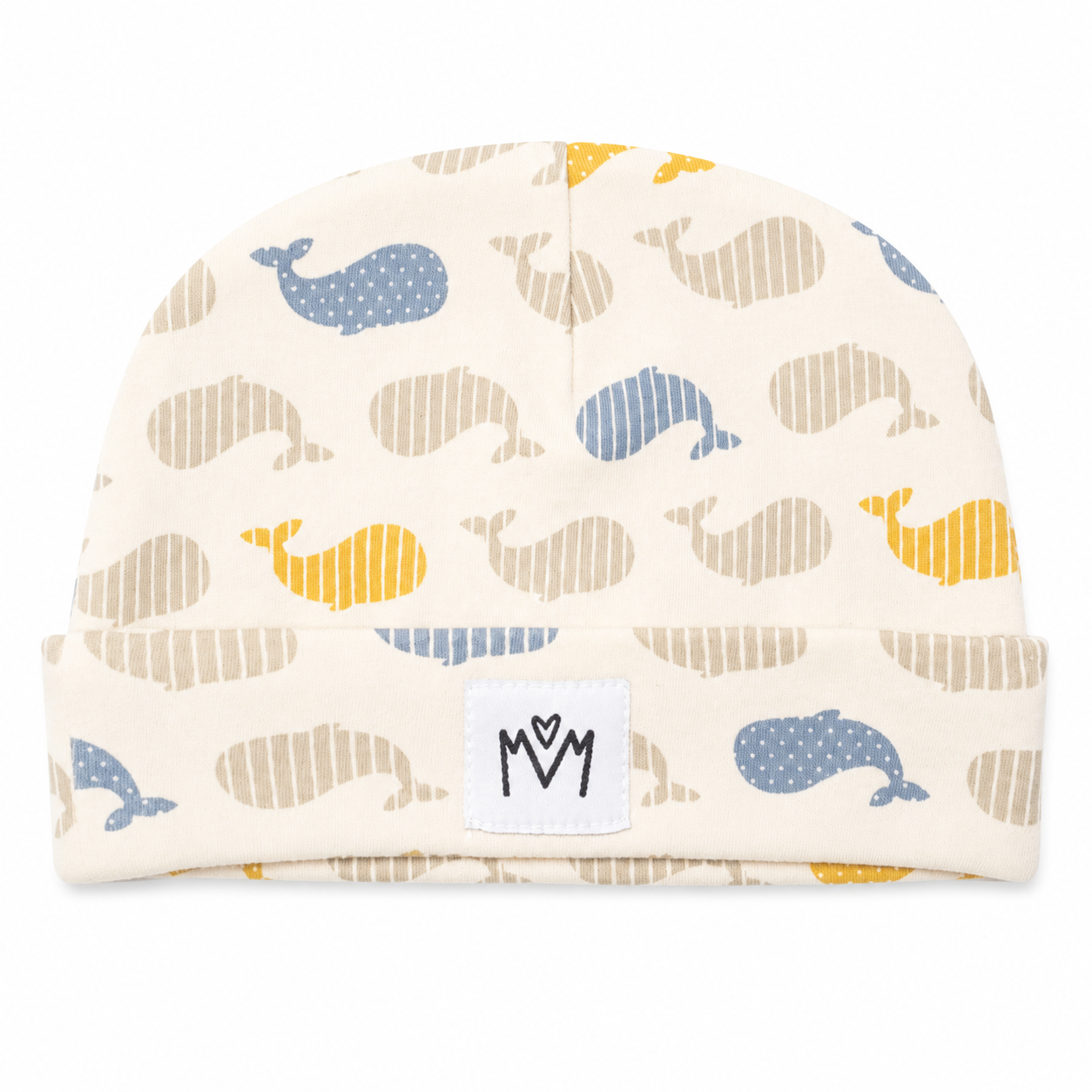 A baby knit beanie hat featuring an all-over whale print in blue, beige, and yellow on a cream background. The hat has a folded cuff with a white brand patch displaying a stylized 'M' logo.