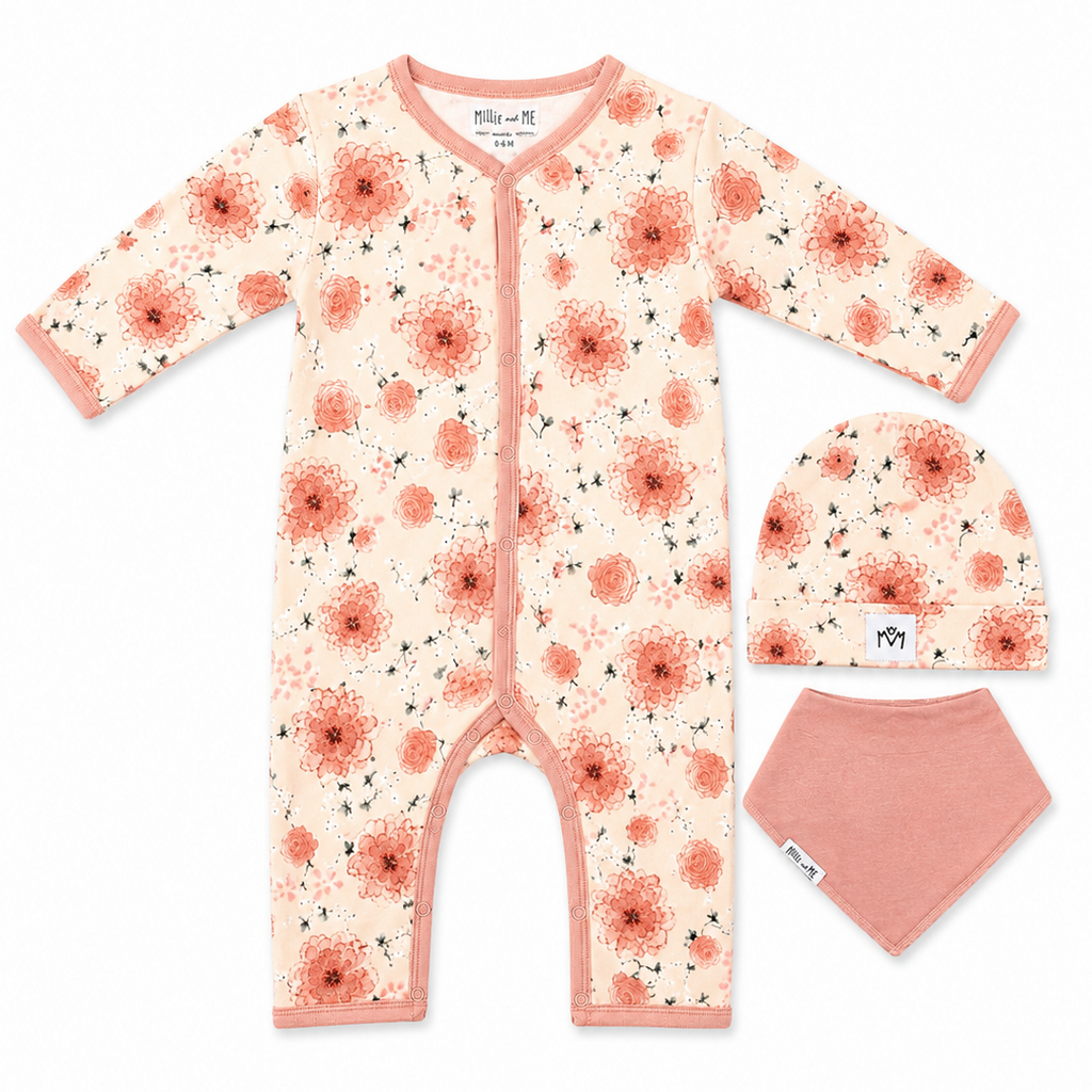 A baby three-piece outfit set including a long-sleeve floral footless romper, a matching beanie, and a solid pink bandana bib, laid out on a white background.