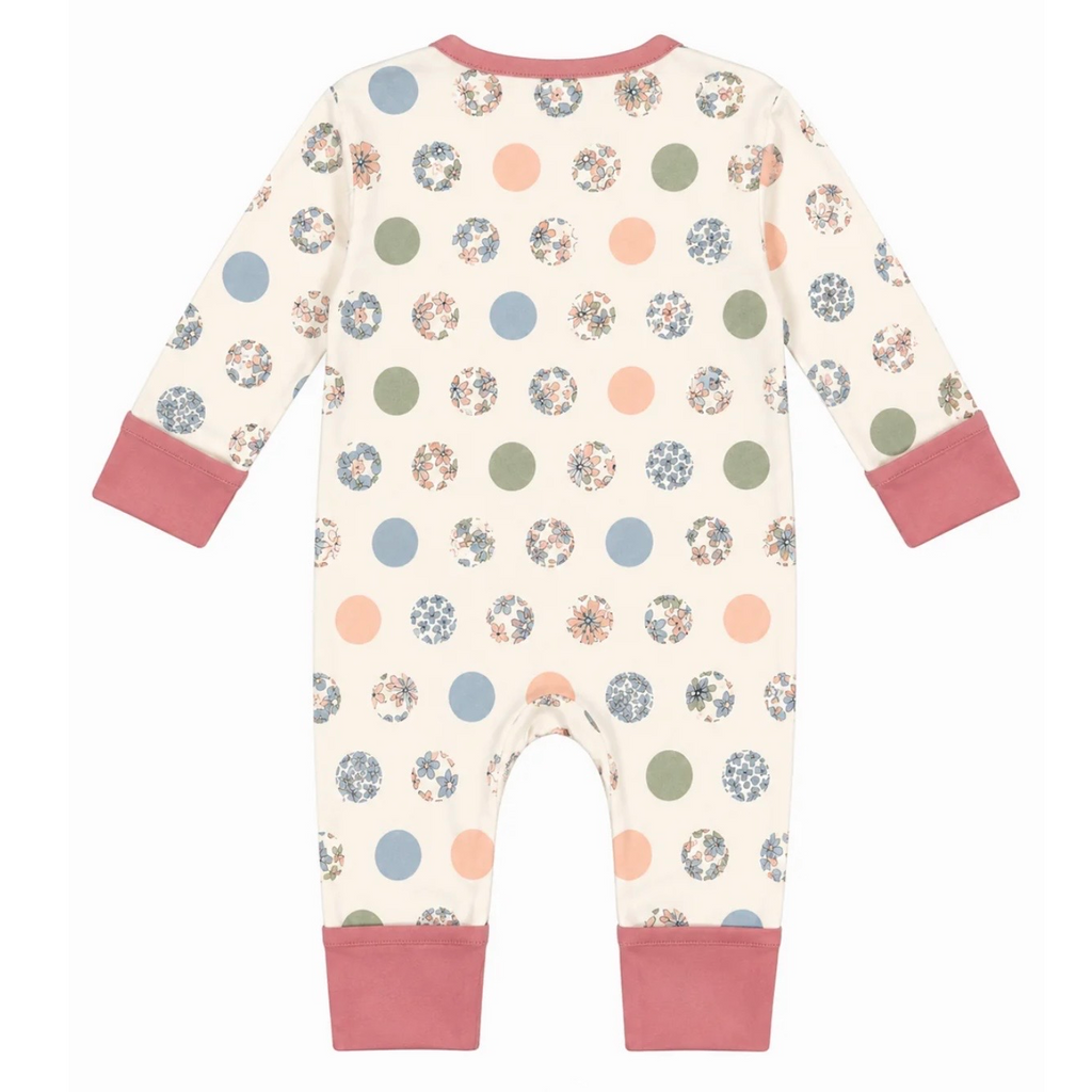 A baby long-sleeve footless jumpsuit shown from the back, featuring an off-white base with a pattern of multicolored polka dots and solid pink cuffs and collar.