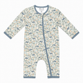 A baby long-sleeve footless one-piece sleeper with an ocean print featuring blue-gray whales, blue-gray fish, and orange accents on a cream background, with blue-gray trim.