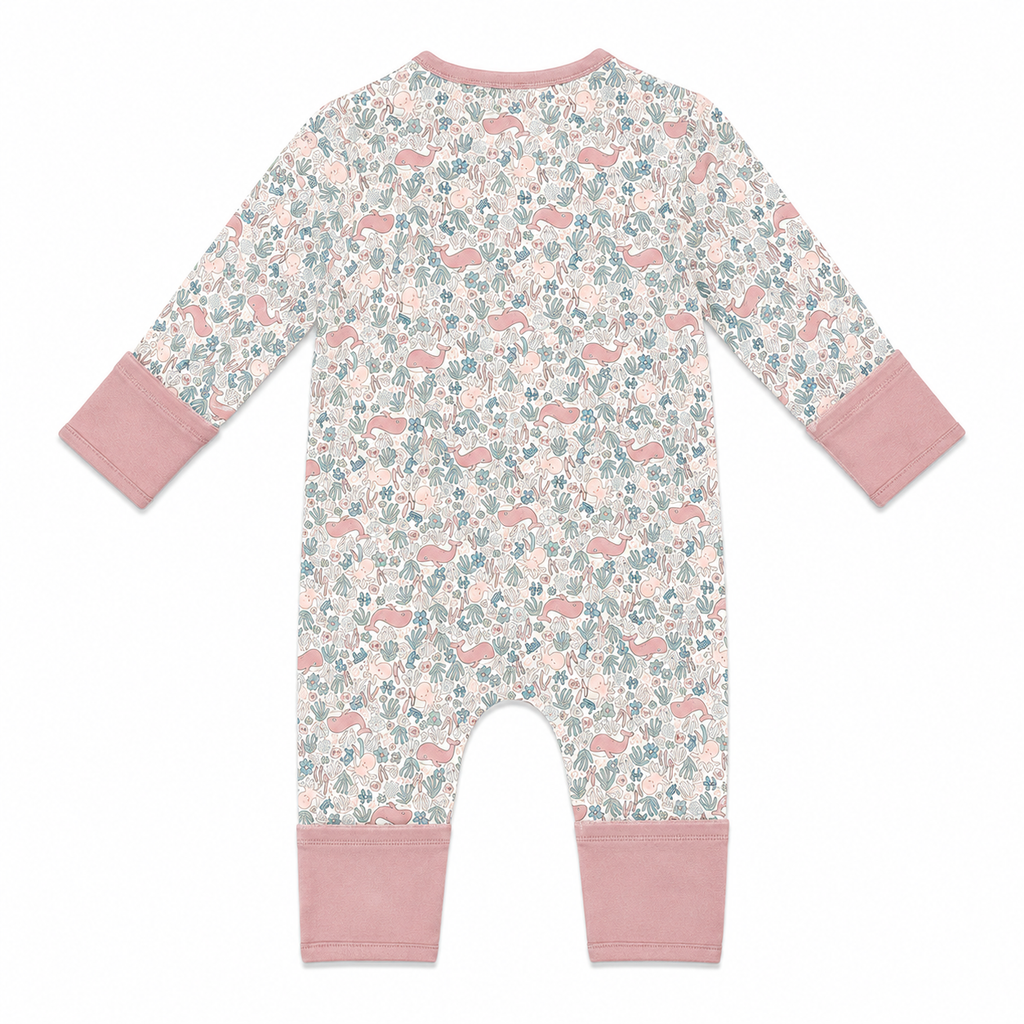 A baby long-sleeve one-piece romper with a pink, blue, and white floral and whale print, featuring a pink zipper and trim, shown on a plain white background.