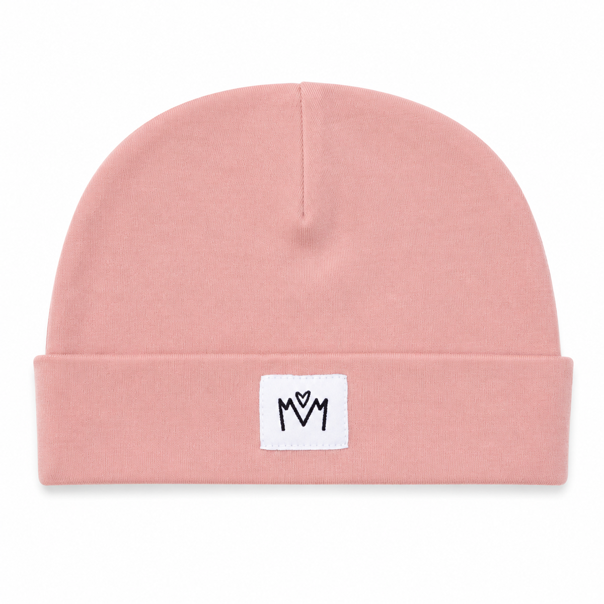 A dusty pink knit beanie hat with a folded cuff, featuring a small white square patch on the front with a black embroidered 'M' logo.