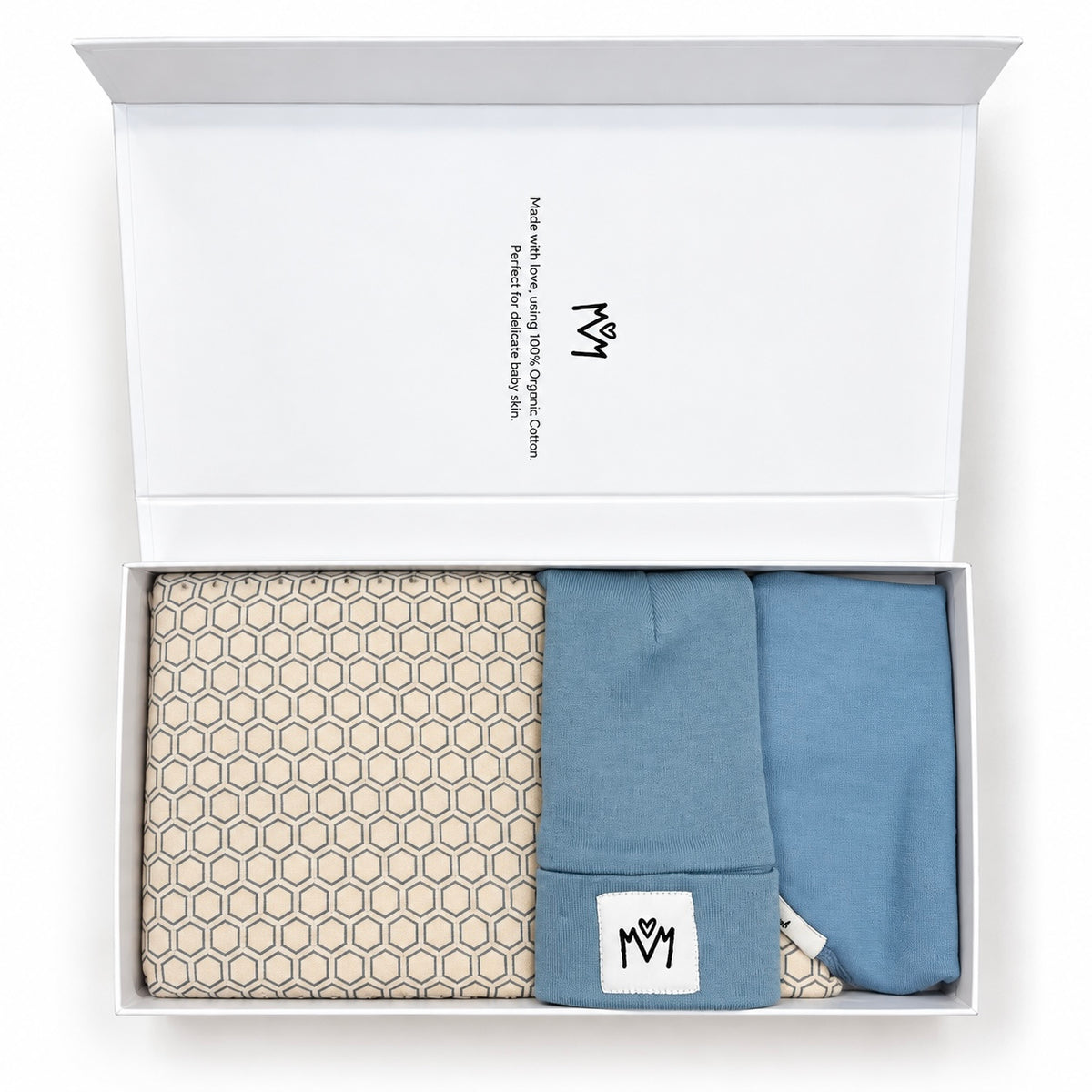 An open white gift box containing folded baby apparel: a beige patterned muslin cloth on the left, a light blue folded hat in the center, and another blue bandana bib on the right. The inside lid shows the brand name and logo printed in black.