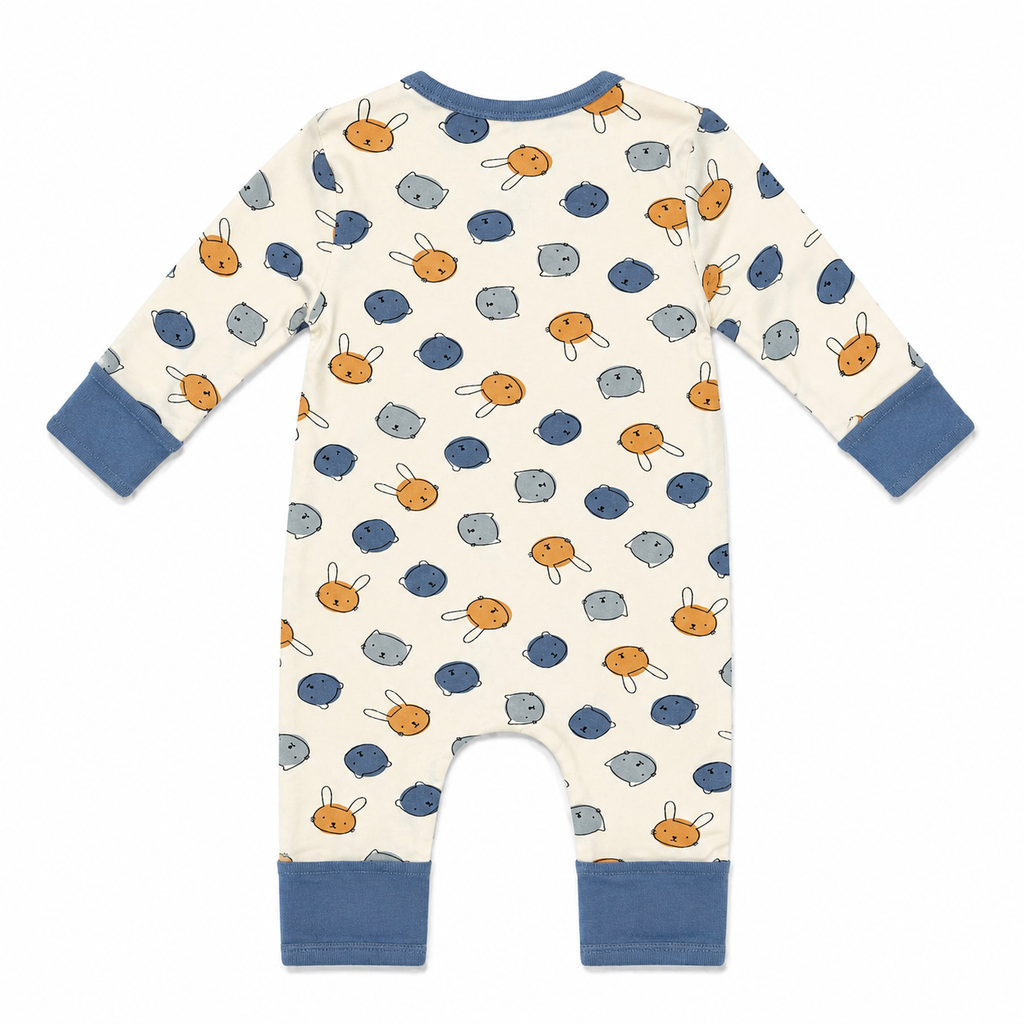 A baby long-sleeve footless romper shown from the back, featuring an off-white background with a playful pattern of blue and orange cartoon faces and blue ribbed cuffs and leg bands.