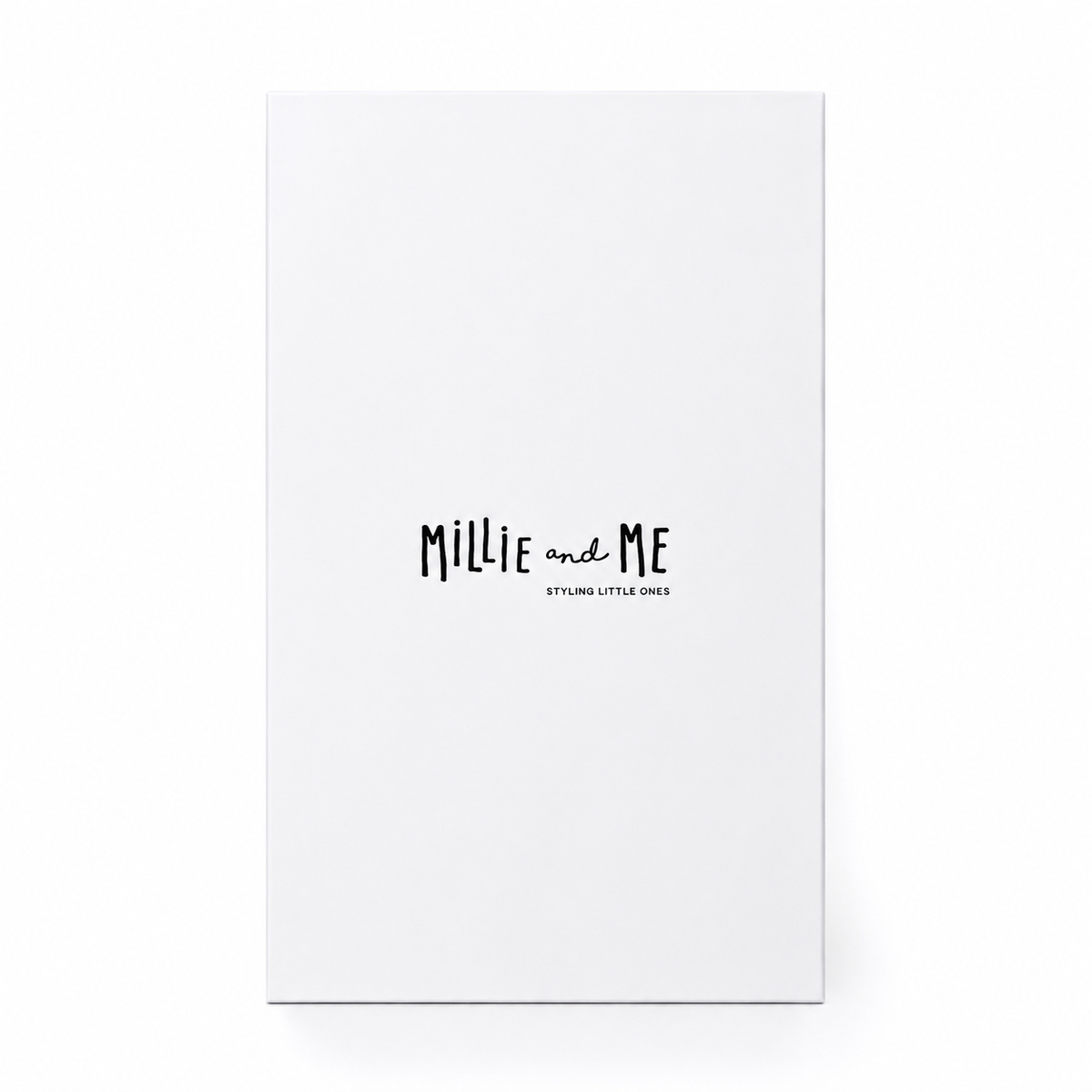 A tall, minimalist white gift box standing upright on a white background. The box features the text 'Millie and Me' in a black handwritten-style font, with 'STYLING LITTLE ONES' printed underneath in smaller text.
