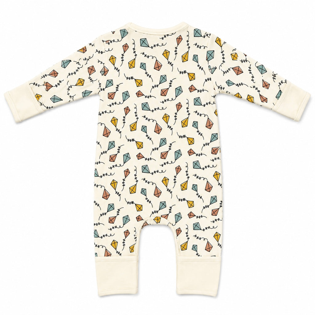 A baby long-sleeve footless one-piece romper in cream with an all-over print of colourful paper kites and squiggly lines, shown flat on a white background.