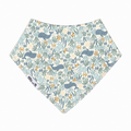 A triangular bandana bib with an all-over ocean-themed pattern featuring blue whales, green seaweed, and small yellow-orange fish on a cream background. A white fabric tag on the left side reads 'Milk & Me'.