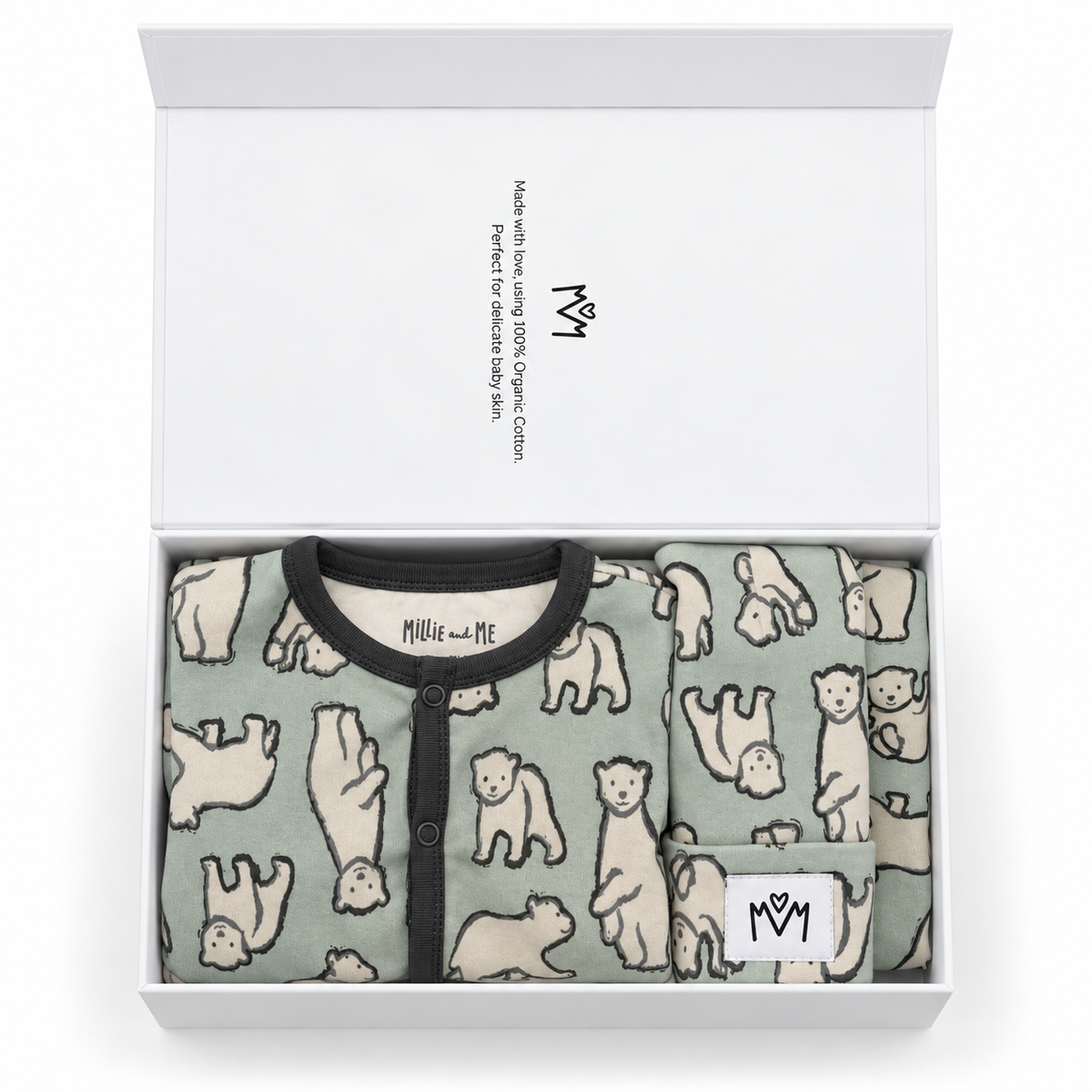 A folded baby long-sleeve babygrow with grey piping and snap-button front, along with a matching bandana bib and hat. The design features an all-over print of polar bears on a sage green background. The item is neatly folded inside an open white gift box with a branded interior.