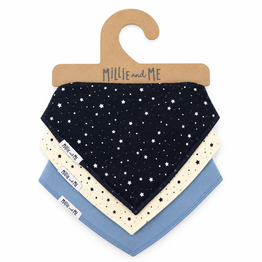 Three baby bandana bibs in different colors and patterns, displayed on a brown cardboard hanger with the brand name 'Millie and Me'. The top bib is navy blue with white stars, the middle is cream with black stars, and the bottom is light blue with black polka dots.