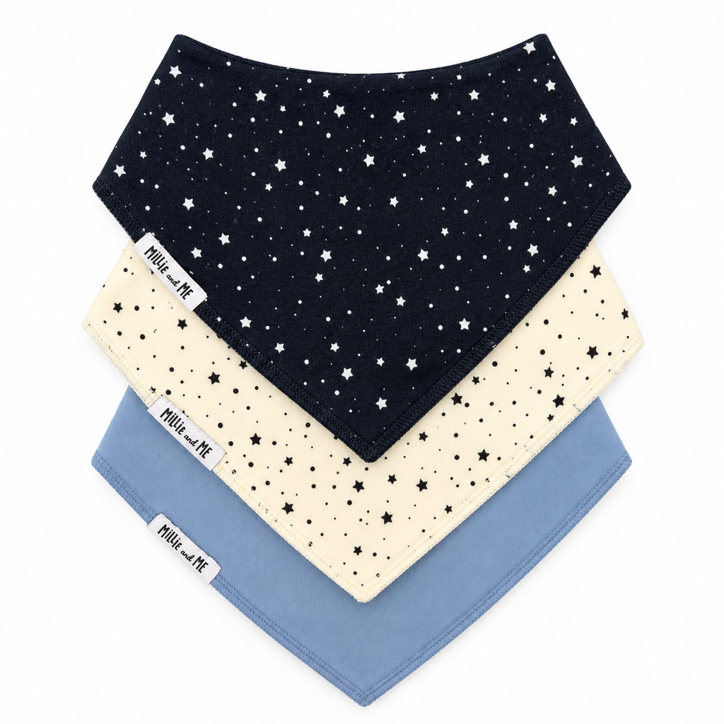 Three baby bandana bibs stacked diagonally on a white background. The top bib is navy blue with white stars, the middle is cream with black stars, and the bottom is light blue with black stars.