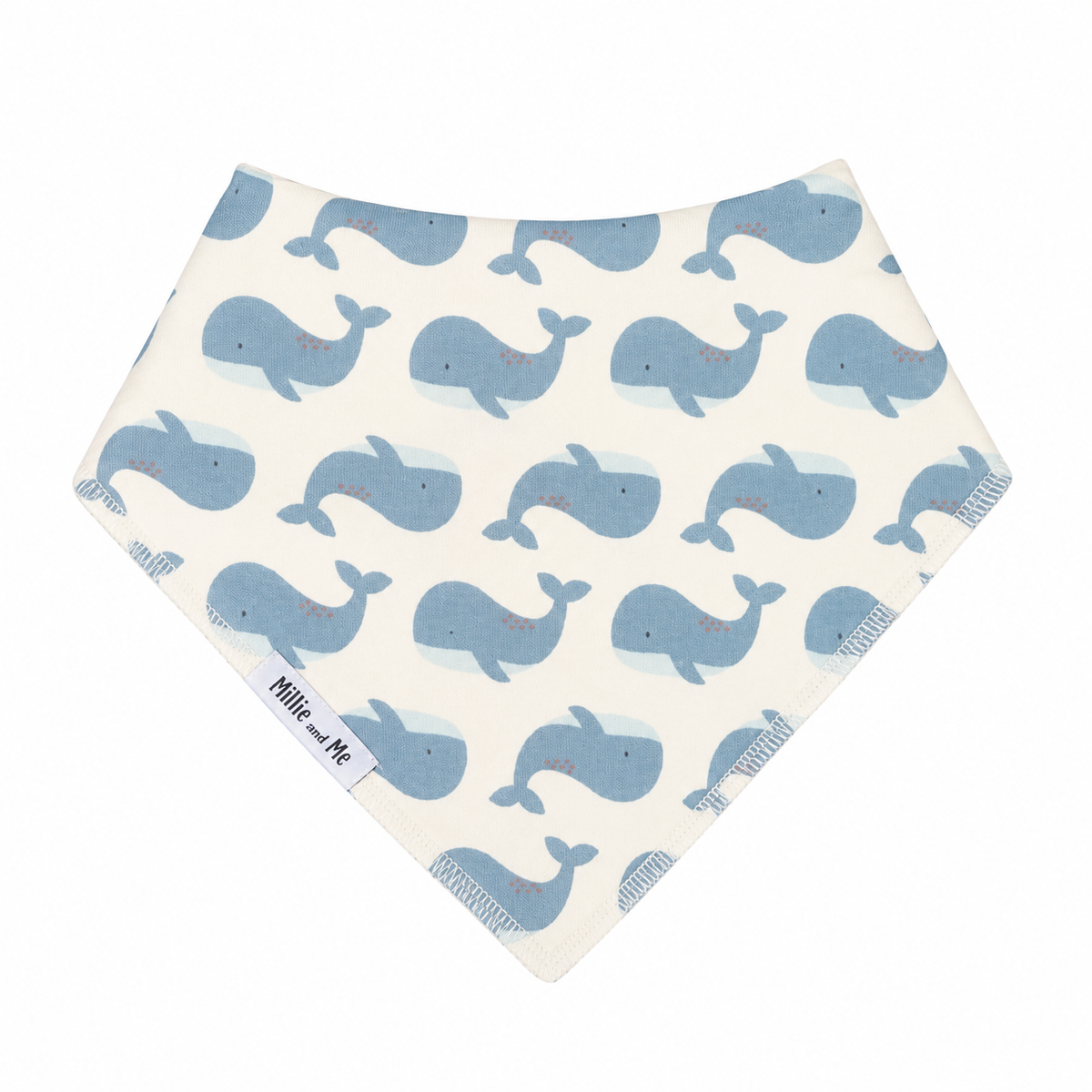 A triangular baby bandana bib with a repeating pattern of light blue whales on an off-white background. The brand name 'Millie and Me' is printed on a small white label near the bottom left corner.