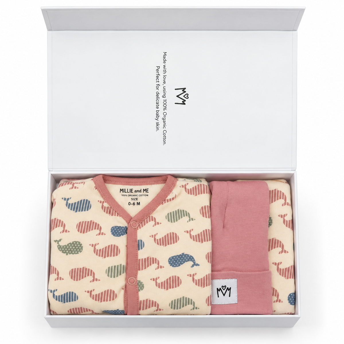 A baby gift set in a white box, featuring a cream-colored babygrow with a colorful whale pattern and a bib and hat.